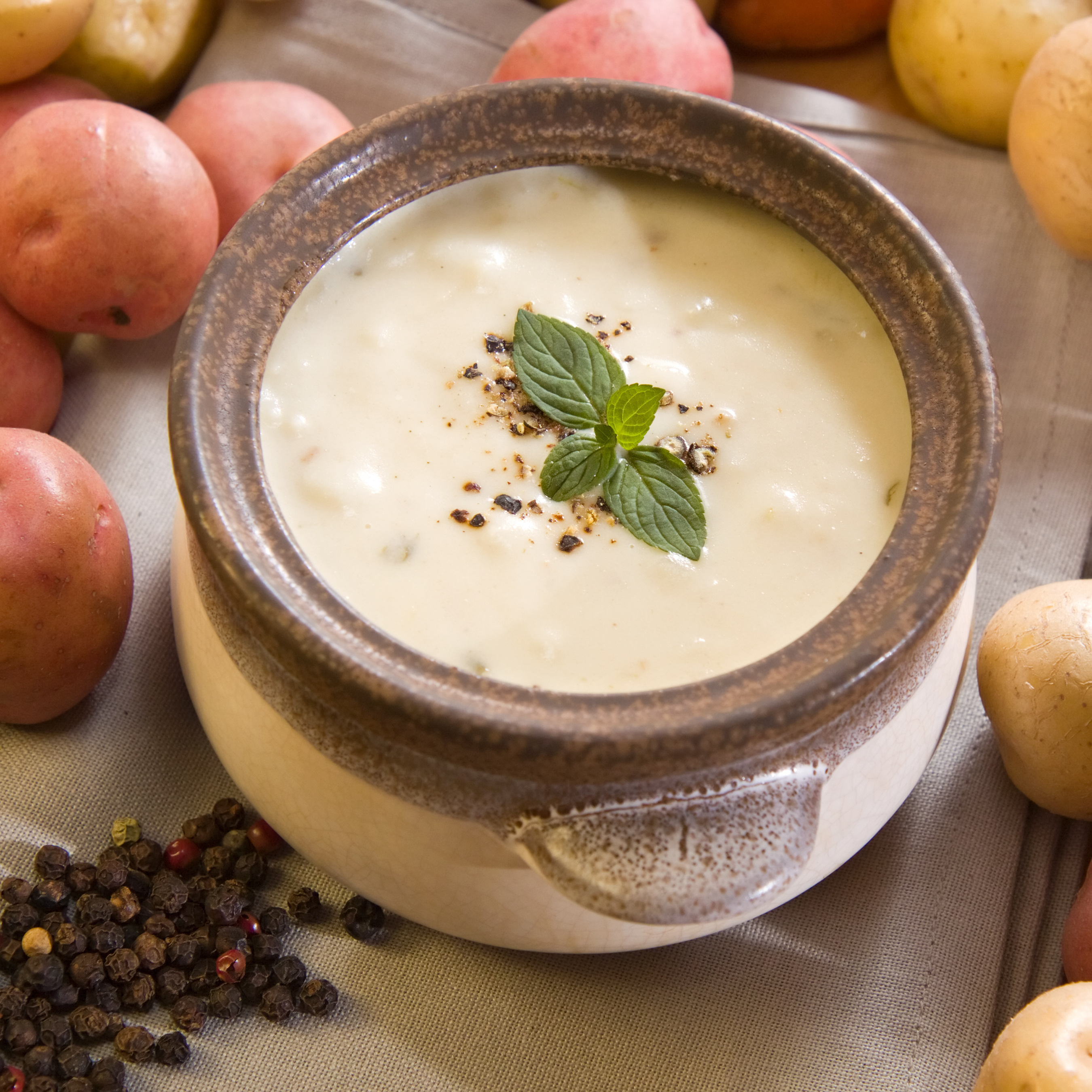 A bowl of freshly made creamy potato soup garnished with mint